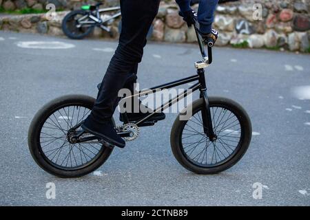 BMX Rider auf schwarzem bmx im Skatepark Nahaufnahme. Street Male Sport Outdoor-Aktivitätskonzept. Stockfoto