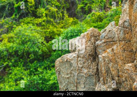 Schöne natürliche Sommer Komposition Wahrzeichen Hintergrund. Hell lebhaft orange braun gelb Stein Felsen schäbig Klippe Risse Textur Berge. Konzept Stockfoto