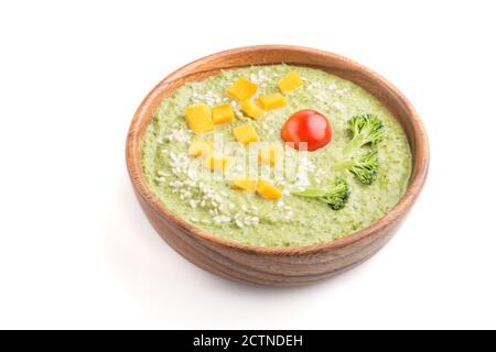 Grüne Brokkoli-Creme-Suppe in Holzschüssel isoliert auf weißem Hintergrund. Seitenansicht, Nahaufnahme. Stockfoto