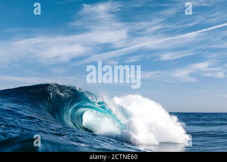 Kraftvolle, blau brechende Meereswellen mit weißem Schaum Stockfoto