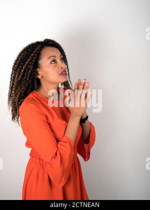 Vertikales Porträt einer afroamerikanischen Frau, die betet Stockfoto