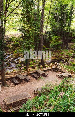 Hohe Winkel der Picknick-Zone mit Holzbänken und Tischen Das Hotel liegt in Wäldern in Valle del Jerte Stockfoto