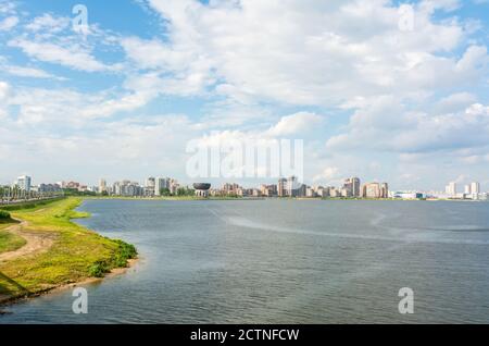 Kasan, Russland – 27. Juni 2017. Blick auf den Fluss Kazanka in Richtung Kazan Wedding Palace in Kazan, mit Gebäuden. Stockfoto