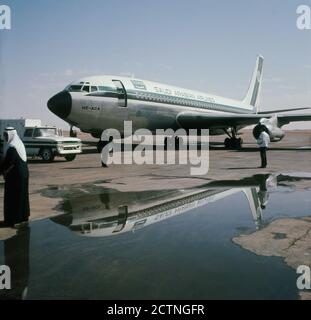 1960er, historisch, Jeddah Flughafen, Saudi Arabian Airlines Jet-Flugzeug, eine Boeing 720 geparkt auf dem Asphalt. Die 1945 gegründete Fluggesellschaft änderte ihren Namen 1972 in Saudia. Stockfoto