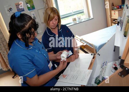 Eine Krankenschwester und Krankenschwester bereiten Medikamente für Patienten in einem Krankenhaus der Gemeinschaft vor; Bradford, Stockfoto