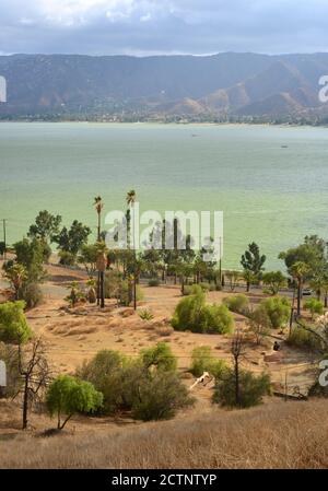 Blick über den Lake Esinore in Kalifornien mit alten Hausstrukturen Verbrannt von Waldbrand Stockfoto