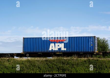 APL Shipping Container auf einem freightliner Zug, Warwickshire, Großbritannien Stockfoto