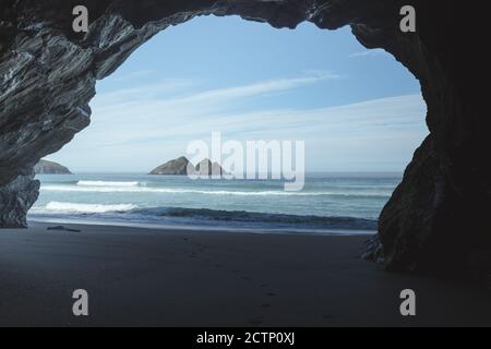 Blick auf den Gull Rock von Holywell Cave in der Holywell Bay Strand Stockfoto