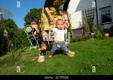 Großelternteil und Enkelkind lernen, Familie im Garten zu gehen Während covid 19 Pandemie im Herbst Sonnenschein Carmarthenshire Wales Großbritannien KATHY DEWITT Stockfoto