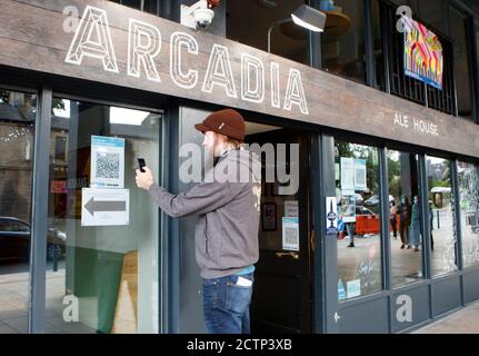 Ein Mann nutzt die Venue Check-in-Funktion der neuen NHS Covid-19 Handy-Anwendung, um einen QR-Code im Arcadia Ale House in Leeds zu scannen, nachdem die App am Donnerstagmorgen live ging. Stockfoto