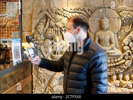 Christopher Hammond, Direktor des Sukhothai Thai Restaurants in Leeds, nutzt die Venue Check-in Funktion der neuen NHS Covid-19 Handy-Anwendung, um einen QR-Code in Sukhothai zu scannen, nachdem die App am Donnerstagmorgen live ging. Stockfoto