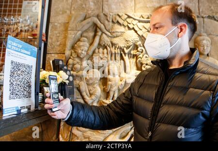 Christopher Hammond, Direktor des Sukhothai Thai Restaurants in Leeds, nutzt die Venue Check-in Funktion der neuen NHS Covid-19 Handy-Anwendung, um einen QR-Code in Sukhothai zu scannen, nachdem die App am Donnerstagmorgen live ging. Stockfoto