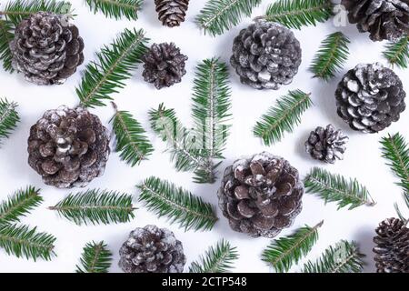 Weihnachten Muster Hintergrund mit schneebedeckten Tannenzweigen und Tannenzapfen auf weißem Hintergrund gemacht. Weihnachten, Neujahr und Winterferien Konzept. Fl Stockfoto