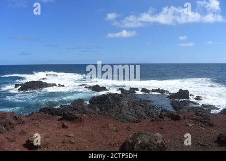 Blick auf die Wellen, die auf die Felsen am Strand treffen wolkiger Hintergrund des Tages Stockfoto