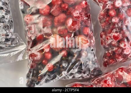 Eisige Beeren für den Winter. Verpackte gefrorene Beeren in Plastiktüten. Im Gefrierschrank. Stockfoto