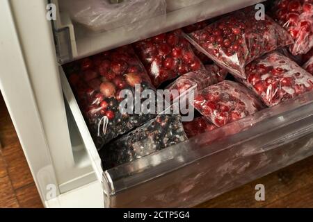 Eisige Beeren für den Winter. Verpackte gefrorene Beeren in Plastiktüten. Im Gefrierschrank. Stockfoto