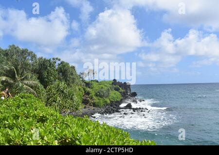 Blick auf die Wellen, die auf die Felsen am Strand treffen wolkiger Hintergrund des Tages Stockfoto
