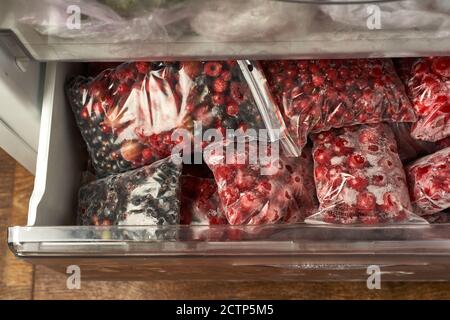 Eisige Beeren für den Winter. Verpackte gefrorene Beeren in Plastiktüten. Im Gefrierschrank. Stockfoto