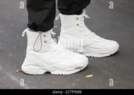 24. September 2020: Ein Modell trägt ein Paar weiße High-Top-Sneaker Stockfoto