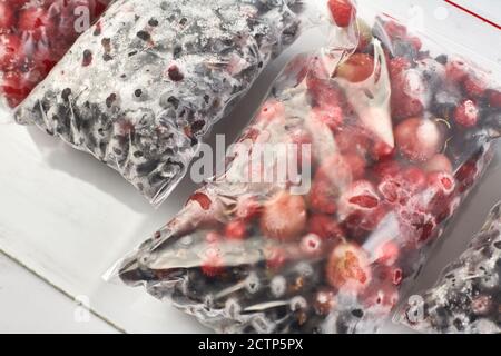 Eisige Beeren für den Winter. Verpackte gefrorene Beeren in Plastiktüten. Im Gefrierschrank. Stockfoto