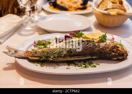 ROM, ITALIEN - 2014. AUGUST 18. Gebratener ganzer Fisch auf einem Gericht in Rom. Stockfoto