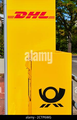 Berlin, Deutschland - 17. September 2020: Gelber Briefkasten der Deutschen Post in der Nähe von Paketboxen von DHL. Stockfoto