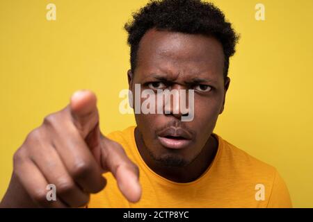 Afroamerikanischer Kerl in gelb casual T-Shirt Entdeckung versteckte Kamera Stockfoto