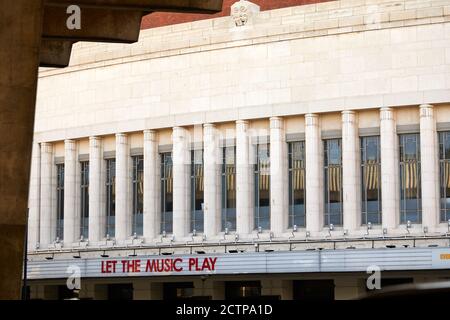 London, Großbritannien. - 13. September 2020: Fassade des Hammersmith Apollo, von Stützen der benachbarten Überführung aus gesehen, mit einer Botschaft an Let the Music Play. Das denkmalgeschützte Art déco-Unterhaltungslokal ist seit Mitte März wegen der Coronavirus-Pandemie geschlossen. Stockfoto