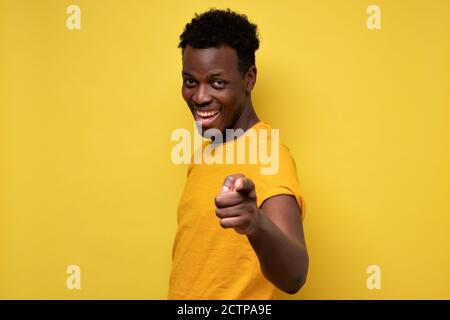Lustiger junger afrikanischer Mann, der glücklich lächelt und seinen Index zeigt Finger an der Kamera Stockfoto