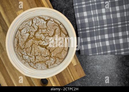 Oben Ansicht der Gärung reines Roggensauerteig Brot in Banneton Auf der Küchentheke Stockfoto
