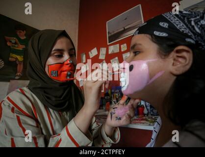 Gaza, Palästina. September 2020. Das palästinensische Mädchen verwendet Wasserfarbe als Maske für das Gesicht eines jungen Mädchens.die neunzehnjährige Ranin Al Zeriei malt Maske auf ihr Gesicht in der Stadt Deir Al Balah im südlichen Gazastreifen inmitten der anhaltenden Coronavirus-Pandemie COVID-19. Kredit: SOPA Images Limited/Alamy Live Nachrichten Stockfoto