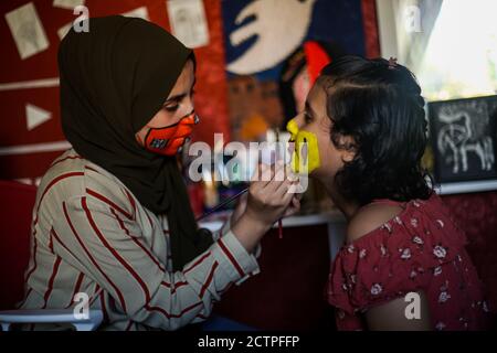 Gaza, Palästina. September 2020. Das palästinensische Mädchen verwendet Wasserfarbe als Maske für das Gesicht eines jungen Mädchens.die neunzehnjährige Ranin Al Zeriei malt Maske auf ihr Gesicht in der Stadt Deir Al Balah im südlichen Gazastreifen inmitten der anhaltenden Coronavirus-Pandemie COVID-19. Kredit: SOPA Images Limited/Alamy Live Nachrichten Stockfoto