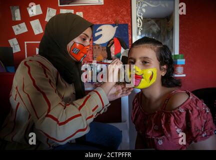 Gaza, Palästina. September 2020. Das palästinensische Mädchen verwendet Wasserfarbe als Maske für das Gesicht eines jungen Mädchens.die neunzehnjährige Ranin Al Zeriei malt Maske auf ihr Gesicht in der Stadt Deir Al Balah im südlichen Gazastreifen inmitten der anhaltenden Coronavirus-Pandemie COVID-19. Kredit: SOPA Images Limited/Alamy Live Nachrichten Stockfoto