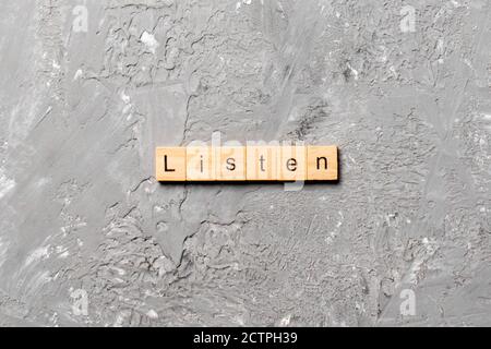 Wort auf Holz Baustein geschrieben hören. Text in Tabelle hören, Konzept. Stockfoto