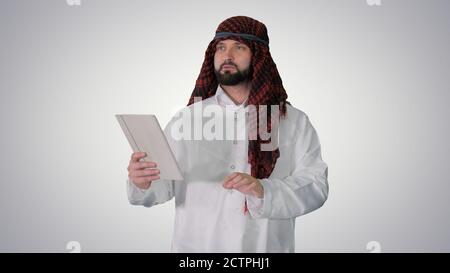 Sheikh mit digitalen Tablet und Gehen auf Gradienten Hintergrund. Stockfoto