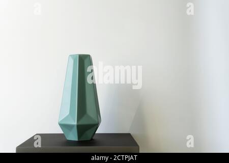 Studioaufnahme einer leeren blauen Vase, die auf einem steht Stehen Sie vor weißem Hintergrund Stockfoto