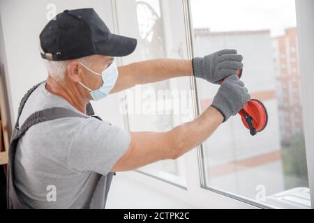 Installiert Kunststoff-upvc-Fenster und Türen Arbeiter in medizinische Maske Stockfoto