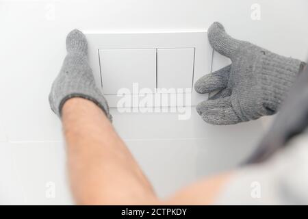 Klempner in medizinische Maske Installation Toilettenschüssel in Toilette, Arbeit im Badezimmer Stockfoto