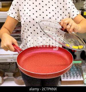 Frau hält die rote Bratpfanne aus nächster Nähe Stockfoto
