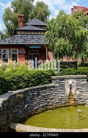 1884 Lititz Passenger Depot, jetzt Welcome Center, altes Ziegelgebäude, Löwenbrunnen in Steinmauer, attraktive Umgebung; Lancaster County; Pennsylvania, Stockfoto