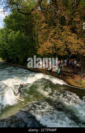 Mann, der die stehende Welle auf dem Eisbach in surft Innenstadt von München Stockfoto