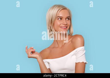 Freistil. Junge blonde Frau in oben isoliert auf blau Blick neben lächelnd fröhlich Stockfoto