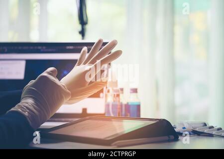 Arzt legt weiße sterilisierte OP-Handschuhe an Stockfoto