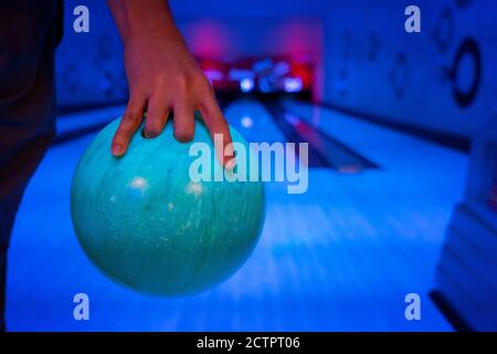Männer Hand hält einen blauen Bowling-Ball bereit zu werfen Stockfoto