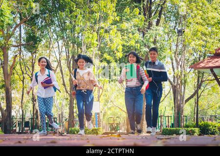 Schüler im Sommer Kinder mit Rucksäcken stehen im Park in der Nähe der Schule. Schüler mit Büchern und Rucksäcken im Freien Stockfoto