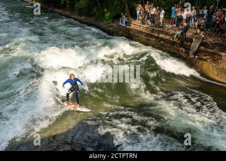 München, Bayern / Deutschland - 17. September 2020: Frau surft auf der stehenden Welle am Eisbach in der Münchner Innenstadt Stockfoto