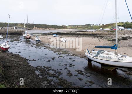 Boote sitzen im Sand und Schlamm im leeren Hafen mit dem Gezeiten am 15. September 2020 in Cemaes Bay, Anglesey, Wales, Vereinigtes Königreich. Cemaes ist ein Dorf an der Nordküste von Anglesey in Wales, gelegen an der Cemaes Bay, einem Gebiet von außergewöhnlicher natürlicher Schönheit, das zum Teil dem National Trust gehört. Es ist das nördlichste Dorf in Wales. Der Name Cemaes leitet sich vom walisischen Wort cemais ab, was soviel bedeutet wie "Biegen oder Schlingen in einem Fluss, Meereseinfluss, Bucht". Stockfoto