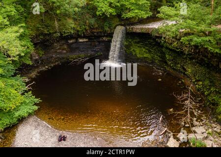 Niedrige Luftaufnahme eines malerischen Wasserfalls in einem üppigen, grünen Wald (Sgwd Gwladys, Wales, UK) Stockfoto