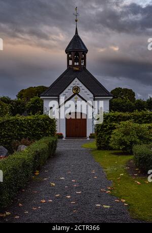 Die kleine Kapelle im Fischerdorf Holm an einem stürmischen Sommertag in Schleswig, Deutschland Stockfoto