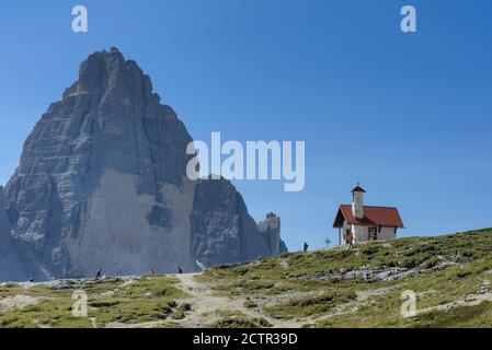 Blick auf die Kapelle der Antonio Locatelli Hütte mit den drei Zinnen im Hintergrund. Sexten Dolomiten, Südtirol, Italien Stockfoto